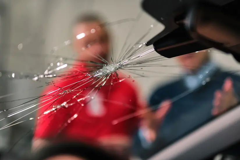 Cracked windshield looking out to Glass Doctor specialist and owner of car